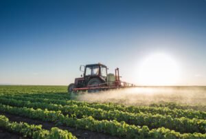 Farmer driving a tractor in a field in the morning